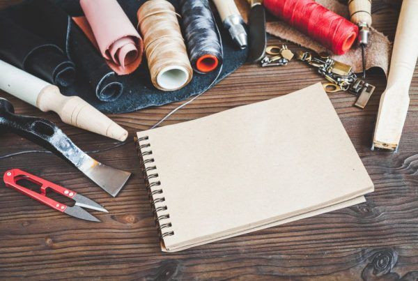 Notes ze spiralą w okładce z szarego kartonu wśród narzędzi rzemieślniczych